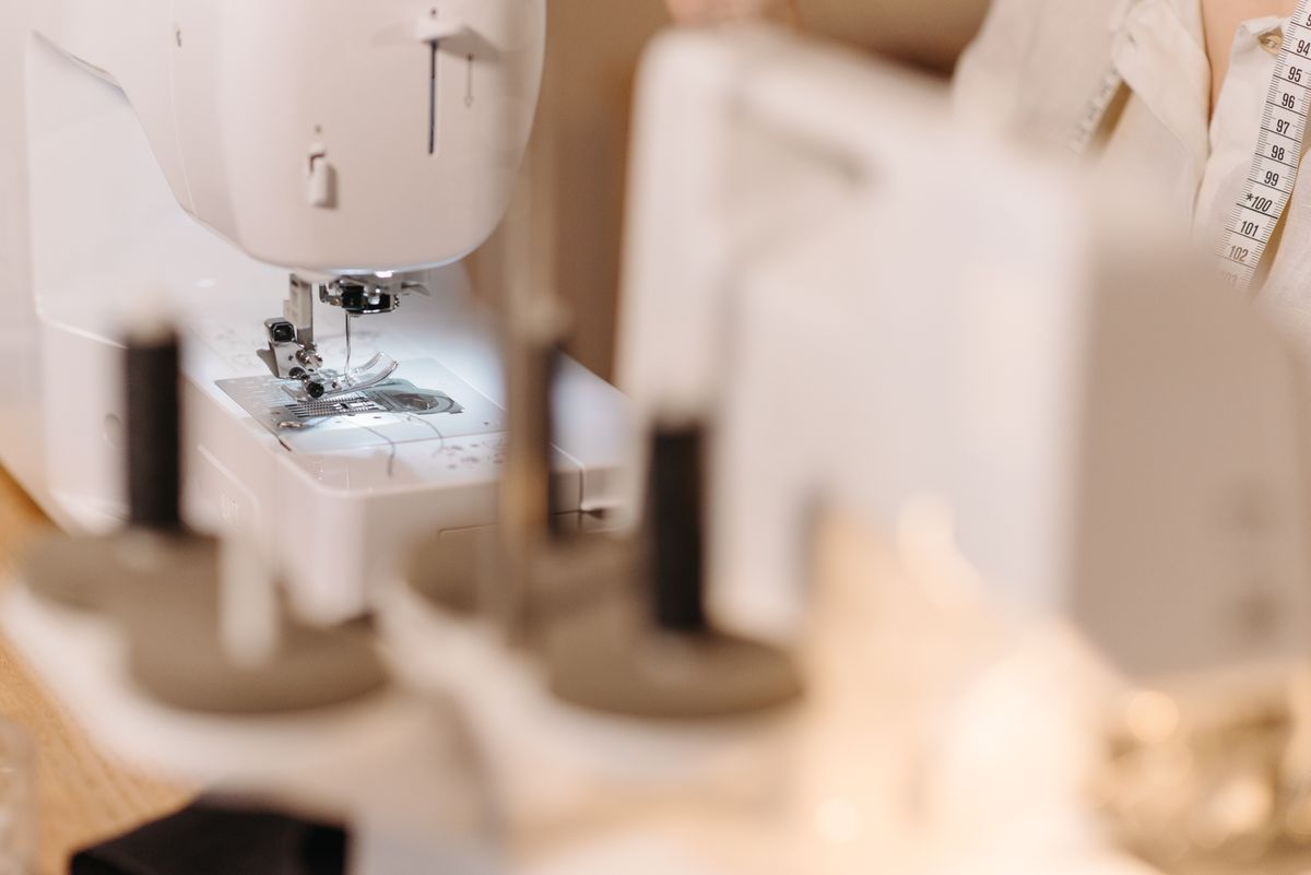 A sewing machine and thread in an alterations workroom